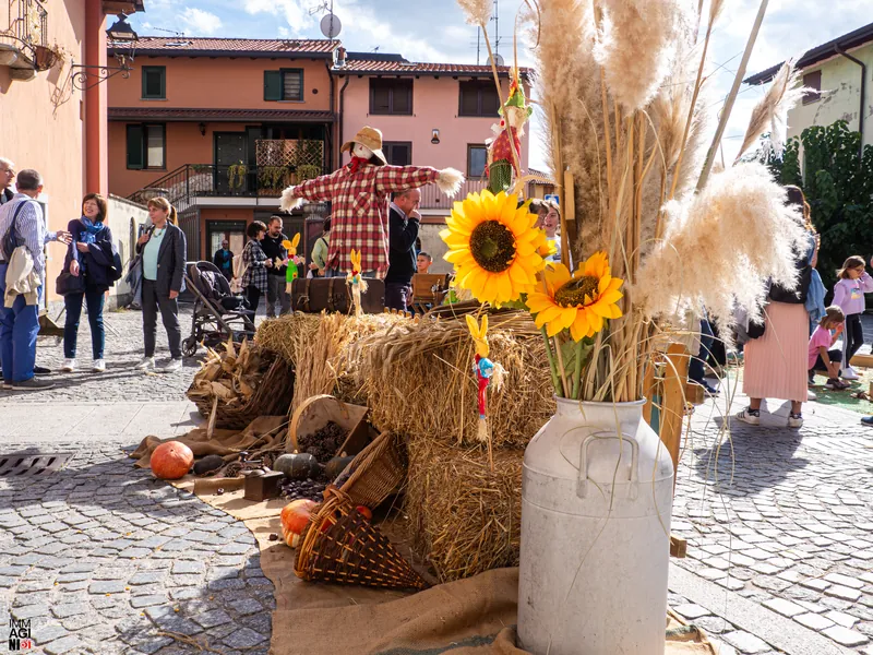 Allestimento d'autunno con spaventapasseri, girasoli e zucche